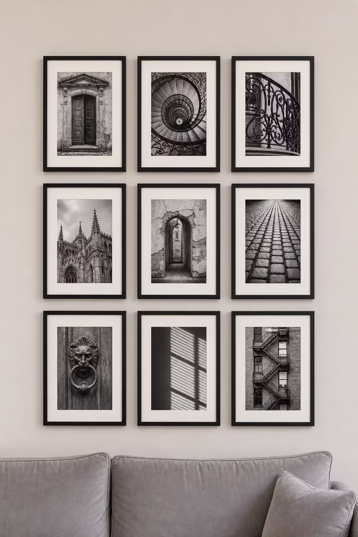 11 Stunning Above Couch Wall Decor Ideas Worth Copying 3 A nine-frame grid of black-and-white architectural photographs in matte black frames above a light gray velvet sofa in cool overcast light