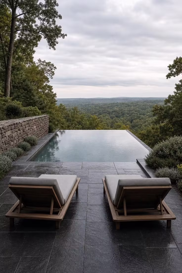 15 Backyard Pool Designs That Bring Resort Comfort Home 7 Infinity edge pool overlooking a wooded valley with bluestone terrace in soft diffused light.