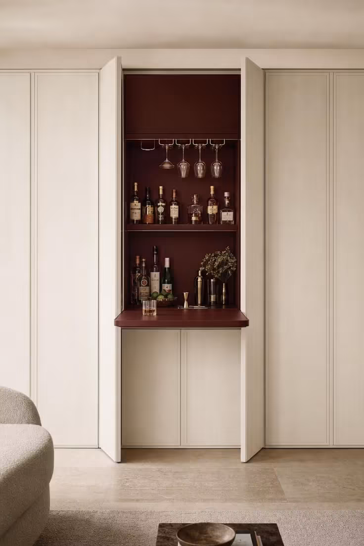 11 Cozy Bar Ideas for Home Living Rooms You'll Love 10 Paneled wall with center panels open to reveal a fold-down shelf bar interior painted deep oxblood