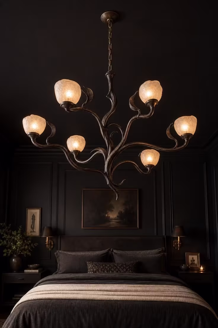 13 Moody Black Nouveau Bedroom Ideas Worth Trying Now 6 Hand-forged iron chandelier with flowing vine-like arms and frosted glass shades hanging over a bed in a black nouveau bedroom.