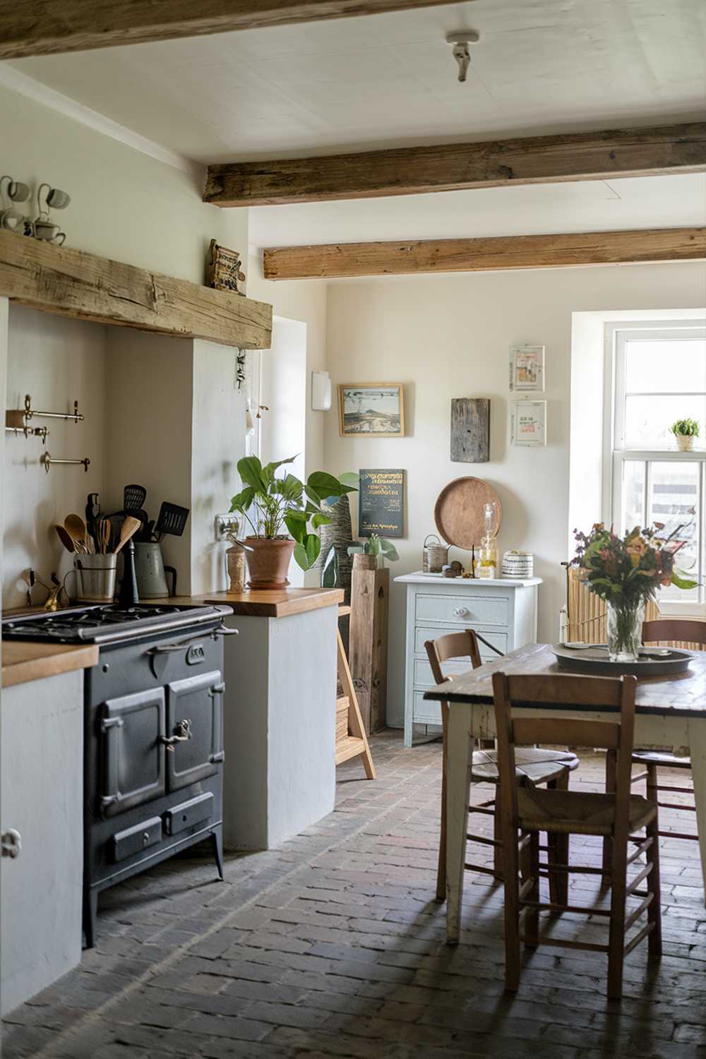 A coastal farmhouse kitchen with a stylish decor. The room features a vintage stove, a wooden countertop, and a rustic table with chairs. There are various cooking utensils, a potted plant, and a vase with flowers. The walls are painted white, and there are wooden beams across the ceiling. The floor is made of red bricks.