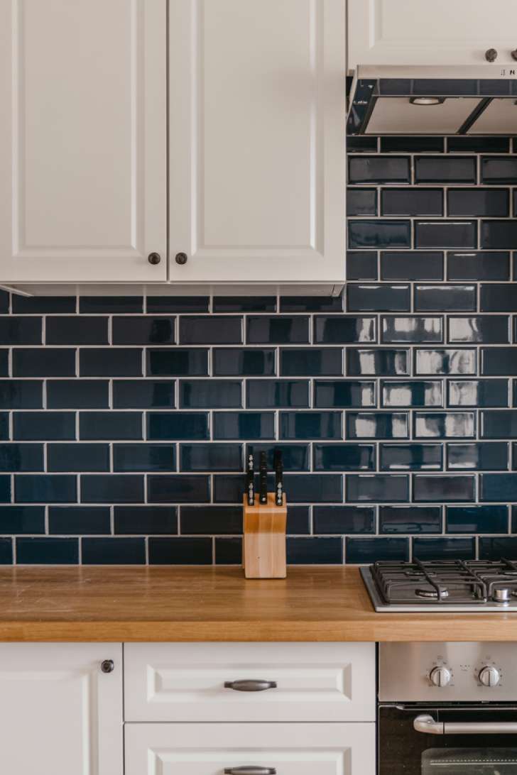 Navy subway tile backsplash with dark grout