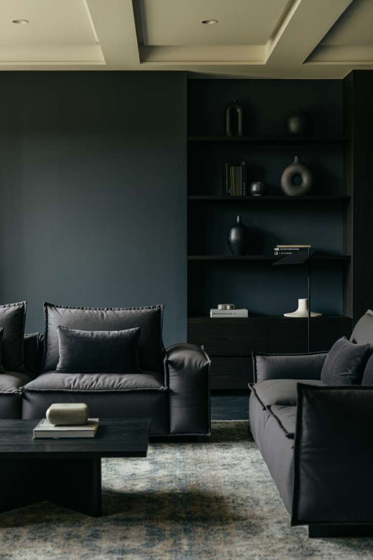 Frontal view living room with slate blue walls and charcoal velvet sectional