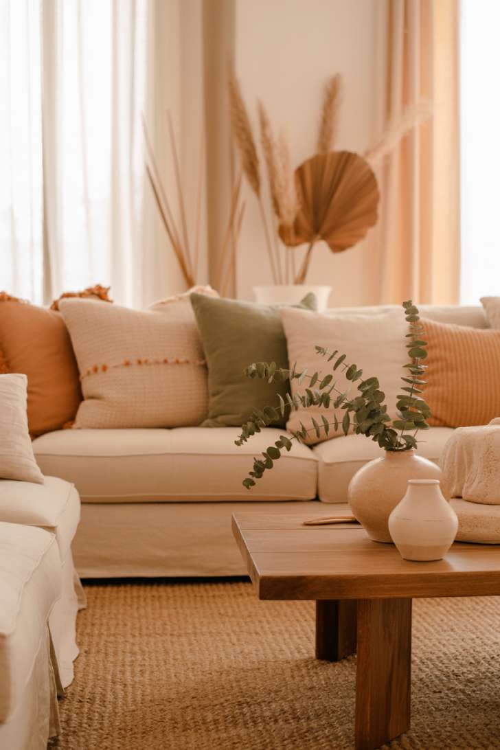 Plush beige sofa with textured pillows and natural fiber rug