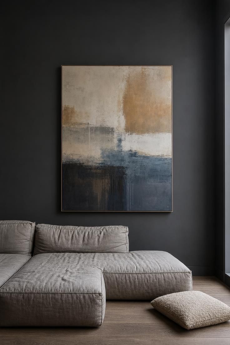 Charcoal matte wall with oversized abstract painting, low stone-gray linen sectional, and oatmeal boucle floor cushion in cool overcast light.