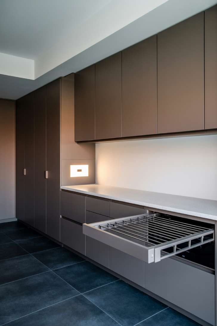 11 Elegant Laundry Room Ideas to Inspire Your Next Makeover 11 Concealed washer dryer behind flat-front cabinetry panels with touchscreen control in modern elegant laundry room