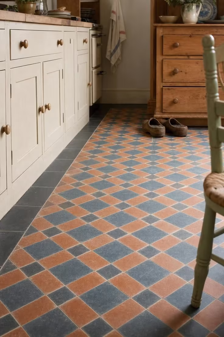 19 English Cottage Kitchen Ideas Full of Old World Charm 4 Encaustic cement floor tiles in terracotta and slate blue geometric pattern in a cottage kitchen with cream cabinetry.