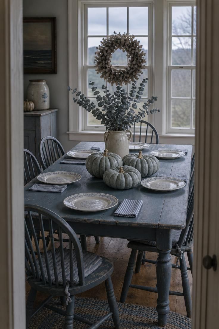 13 Cozy Fall Dining Table Decor Ideas for Warm Gatherings 11 Chalk-painted blue-gray table with Jarrahdale pumpkins, dried blue eucalyptus, and pale blue transferware plates.