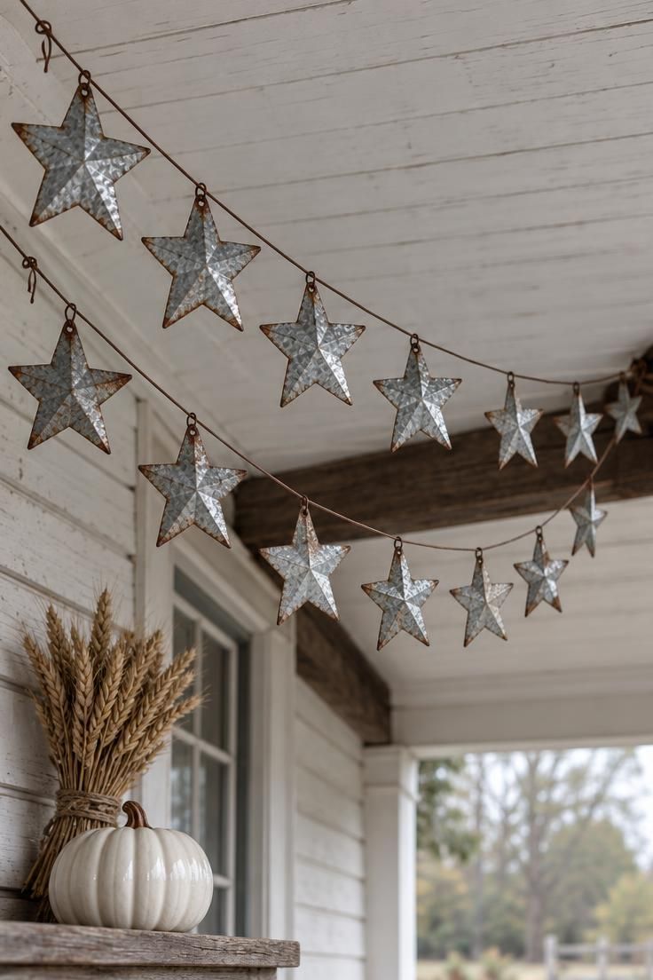 11 Whimsical Farmhouse Halloween Porch Decor Ideas 2 Pressed tin stars strung across a farmhouse porch ceiling with a dark wooden beam and a porcelain pumpkin below.