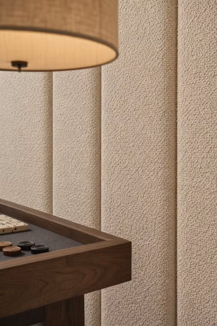 13 Stylish Game Room Ideas for Adults to Lounge and Play 8 Close-up of boucle acoustic wall panels with a walnut table edge and fabric drum pendant.