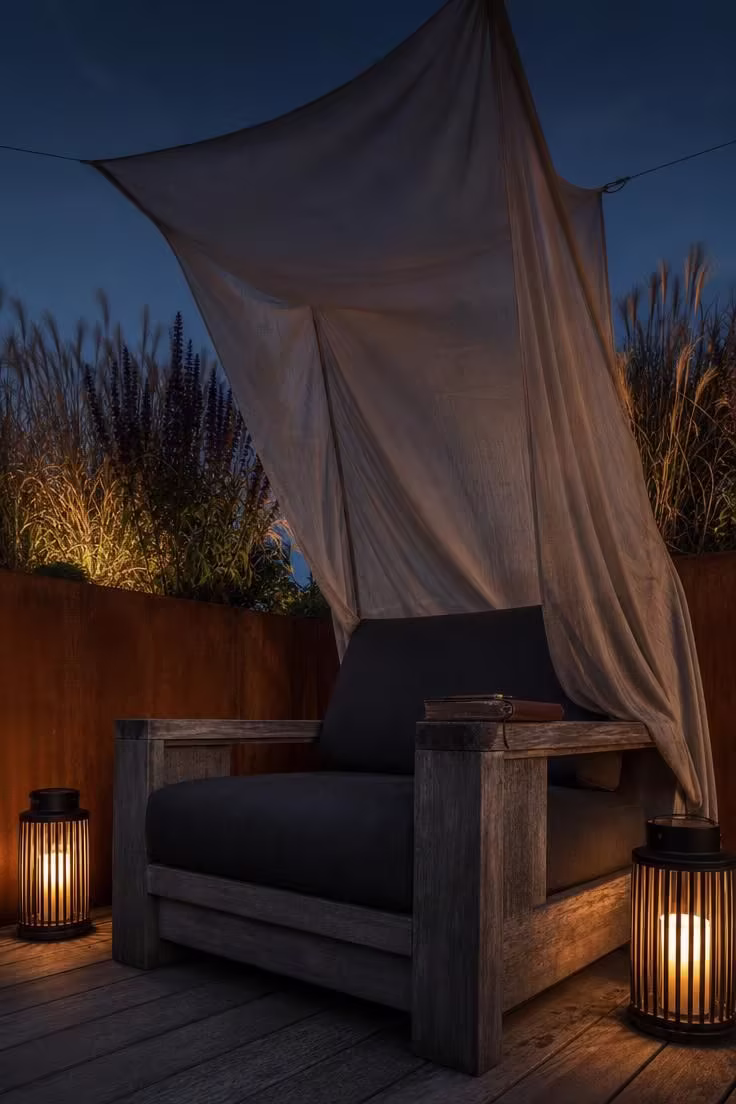 13 Lovely Garden Reading Nook Ideas for Quiet Moments 6 Corten steel planter wall with teak lounge chair and linen canopy at dusk in moody low light