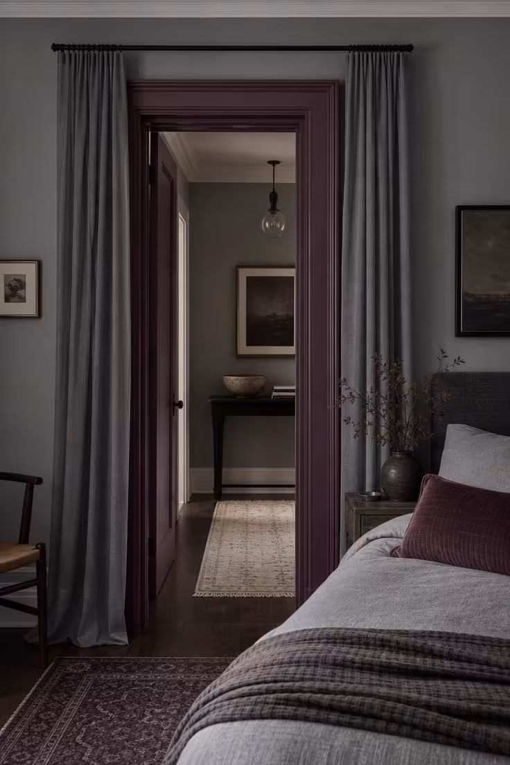 Bold plum painted door frame flanked by heather grey sheer panels in cool overcast light