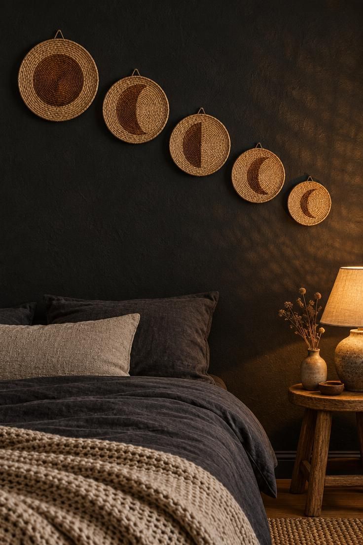 Five woven rattan moon phase plaques in graduated sizes hung in a rising crescent across a matte black wall