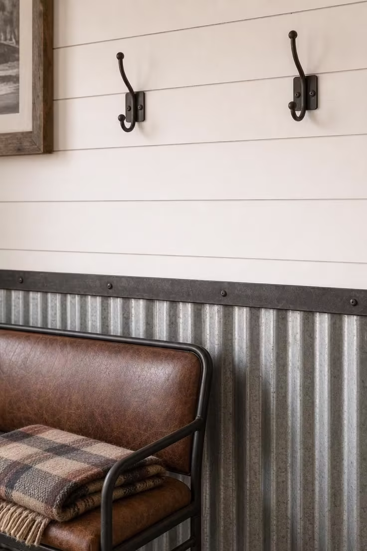11 Charming Industrial Farmhouse Living Room Ideas to Steal 10 Close-up of corrugated metal wainscoting below a white shiplap living room wall with a flat iron chair rail divider.