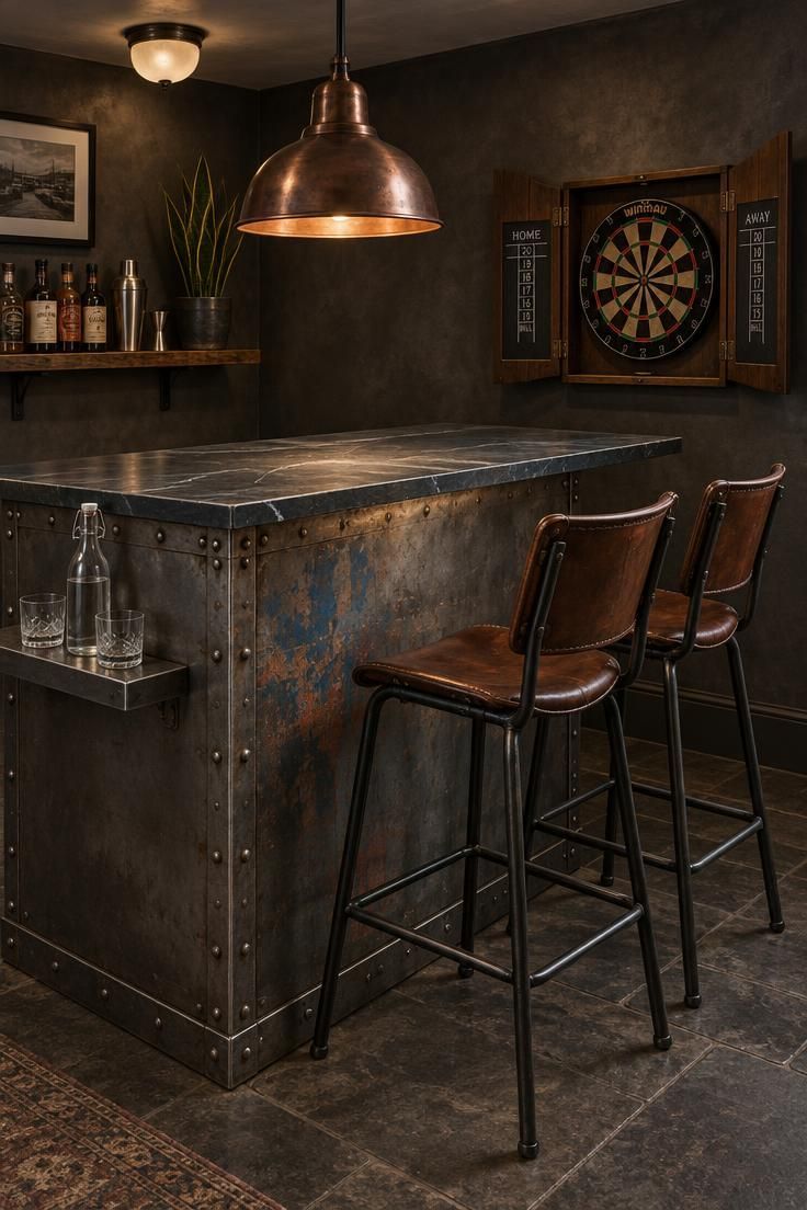 13 Warm Industrial Man Cave Ideas for Your Hangout 5 A riveted steel bar counter with a slate top, copper task lamp, and two black steel and leather bar chairs in a moody lounge.