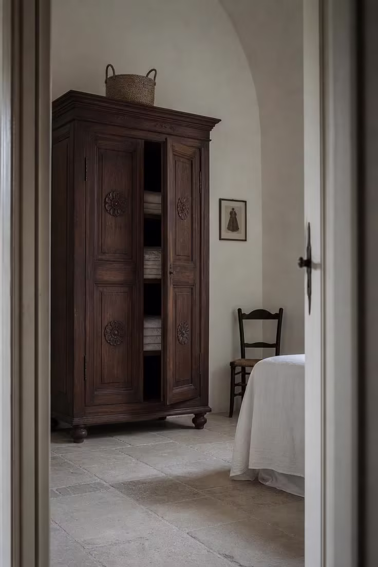 11 Breezy Italian Summer Bedroom Ideas for Lazy Afternoons 5 Carved chestnut armadio wardrobe with paneled doors in a cool Italian summer bedroom.