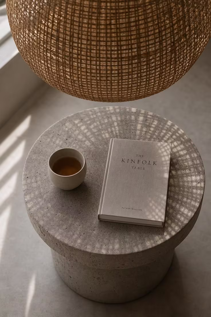13 Gentle Japandi Reading Nook Ideas for Restful Rooms 12 An overhead view of a rounded concrete stool under a woven reed pendant light with shadow patterns in a softly diffused japandi reading nook.