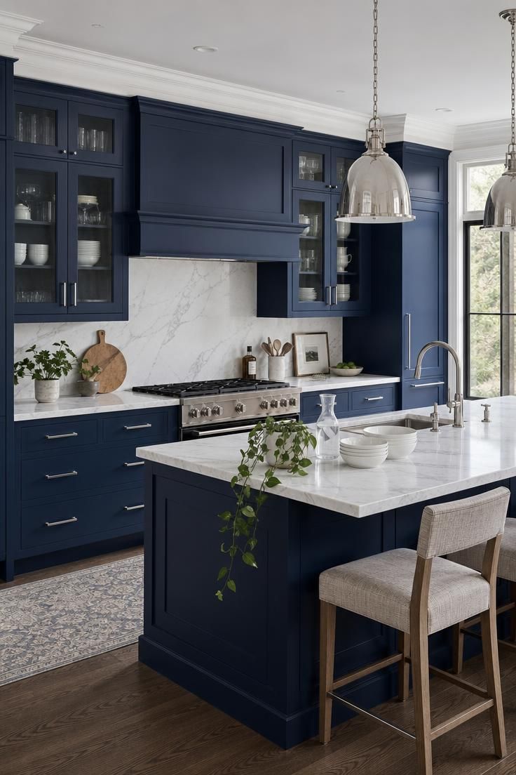 13 Fresh Kitchen Color Palette Ideas to Try This Year 2 Navy blue cabinets with white marble counters and polished nickel hardware in a bright kitchen.