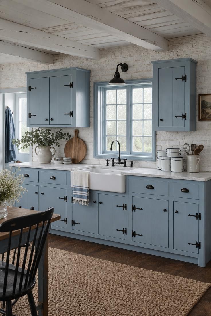 13 Fresh Kitchen Color Palette Ideas to Try This Year 8 Dusty blue cabinets with whitewashed brick and black iron hardware in a cottage kitchen.
