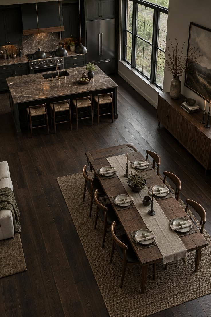 A Complete Guide to Styling Kitchens with Dark Wood Floors 6 An overhead view of an open-plan kitchen and dining area with dark wood flooring flowing continuously into the dining zone under large windows.