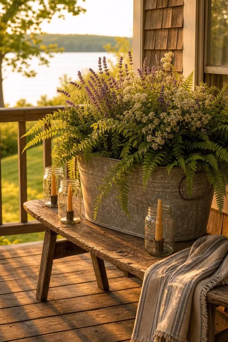 11 Lake Cottage Decor Ideas Packed With Rustic Warmth 6 A galvanized metal tub filled with trailing ferns and wildflowers on a cedar bench in warm golden porch light