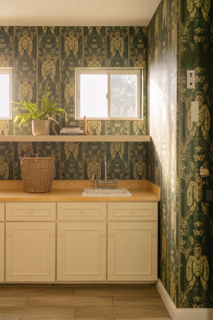 13 Simple Laundry Room Decor Ideas for a Beautiful Space 1 A laundry room with bold botanical wallpaper paired with white shaker cabinets and a marble countertop