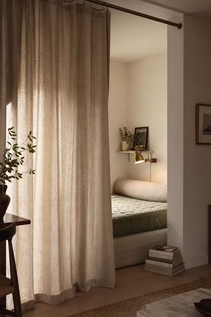 11 Living Room Reading Nook Ideas That Feel Like Home 7 Floor-to-ceiling linen curtain partition revealing a cotton daybed reading nook with soft diffused light.