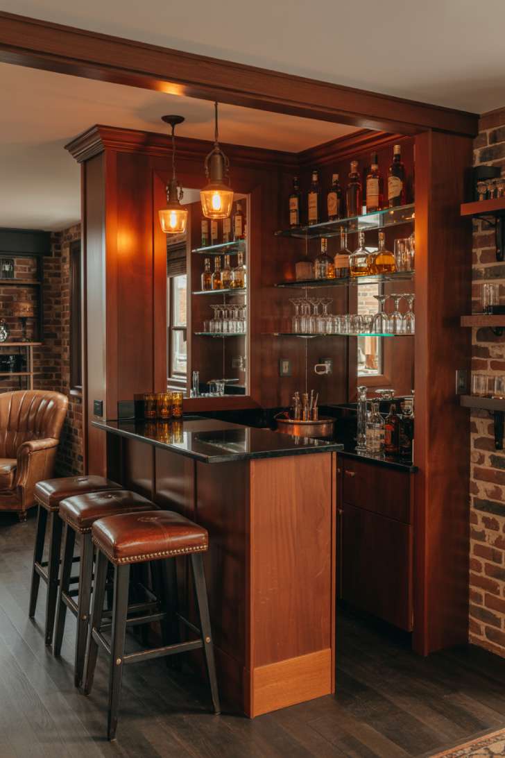 Cozy home bar with mirrored backsplash and floating shelves