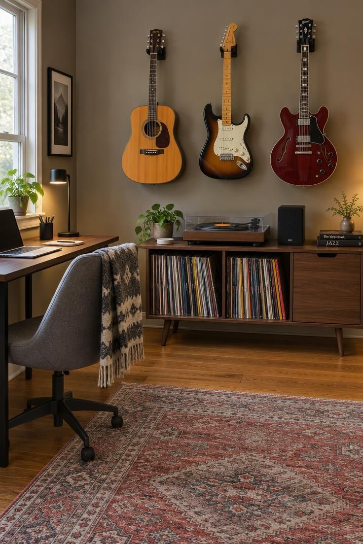 11 Cozy Man Cave Office Ideas to Make Your Space Yours 11 A music room wall with three guitars hung on black wall mounts above a low walnut record cabinet holding a turntable and vinyl, with a compact desk and gray upholstered chair to the left.