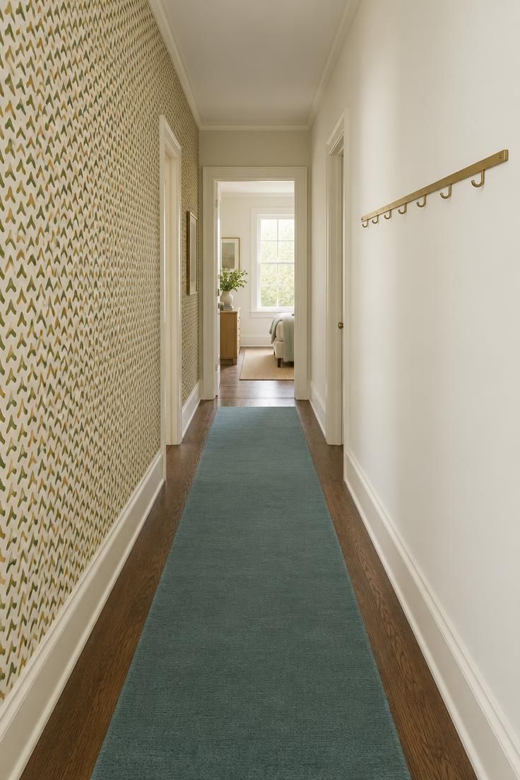 13 Warm Mid Century Modern Hallway Ideas with Wood and Brass 9 Hallway with a boomerang-patterned wallpaper accent wall in olive and mustard facing a plain warm white wall with a brass hook rail.