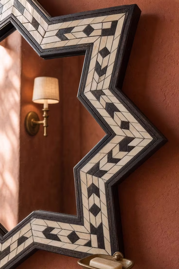 Moroccan eight-pointed star mirror with white bone inlay border on a terracotta wall