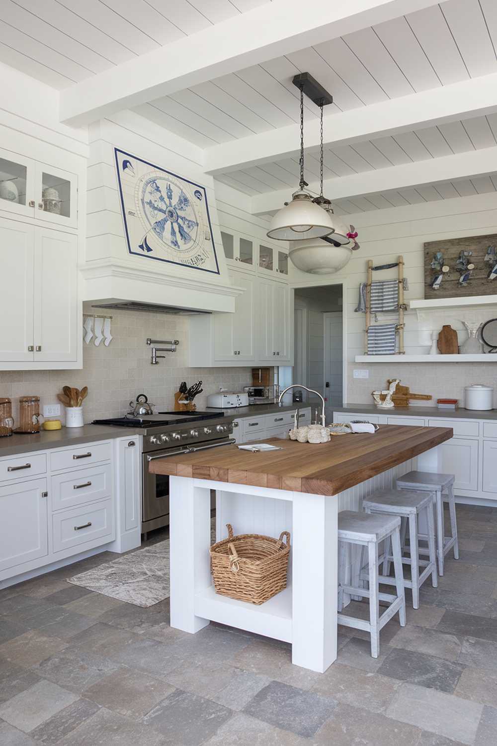 Spacious modern coastal kitchen with white cabinets, gray countertops, and nautical wall decor