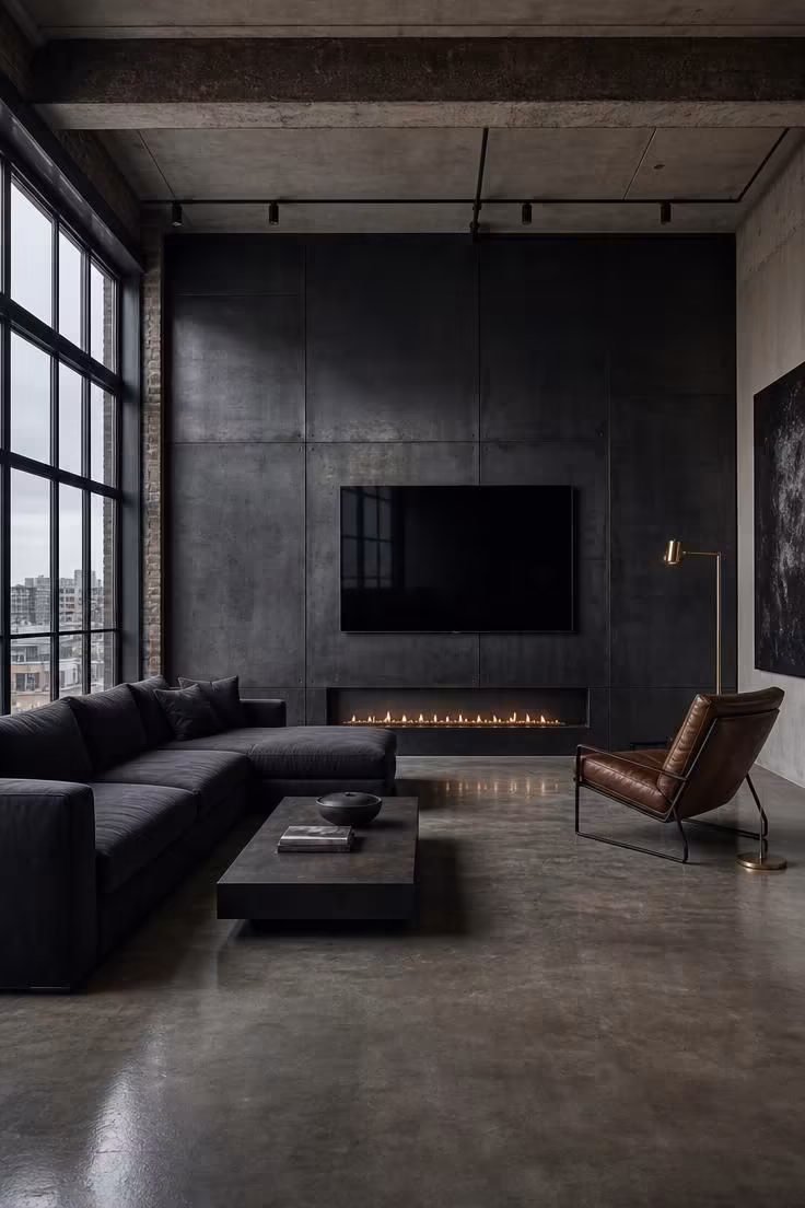 11 Modern Fireplace Ideas With TV for a Cozy Living Room 4 A blackened steel wall with a floor-level linear gas fireplace and slim-frame TV above, styled with a charcoal sectional and brass floor lamp in cool overcast light.