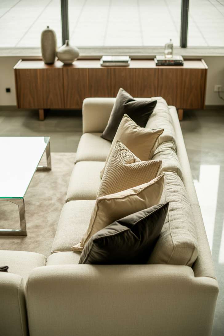 11 Gorgeous Modern Neutral Living Room Ideas for Ease 1 Stylish modern neutral living room with cream sectional, walnut console, and polished concrete floors bathed in natural light