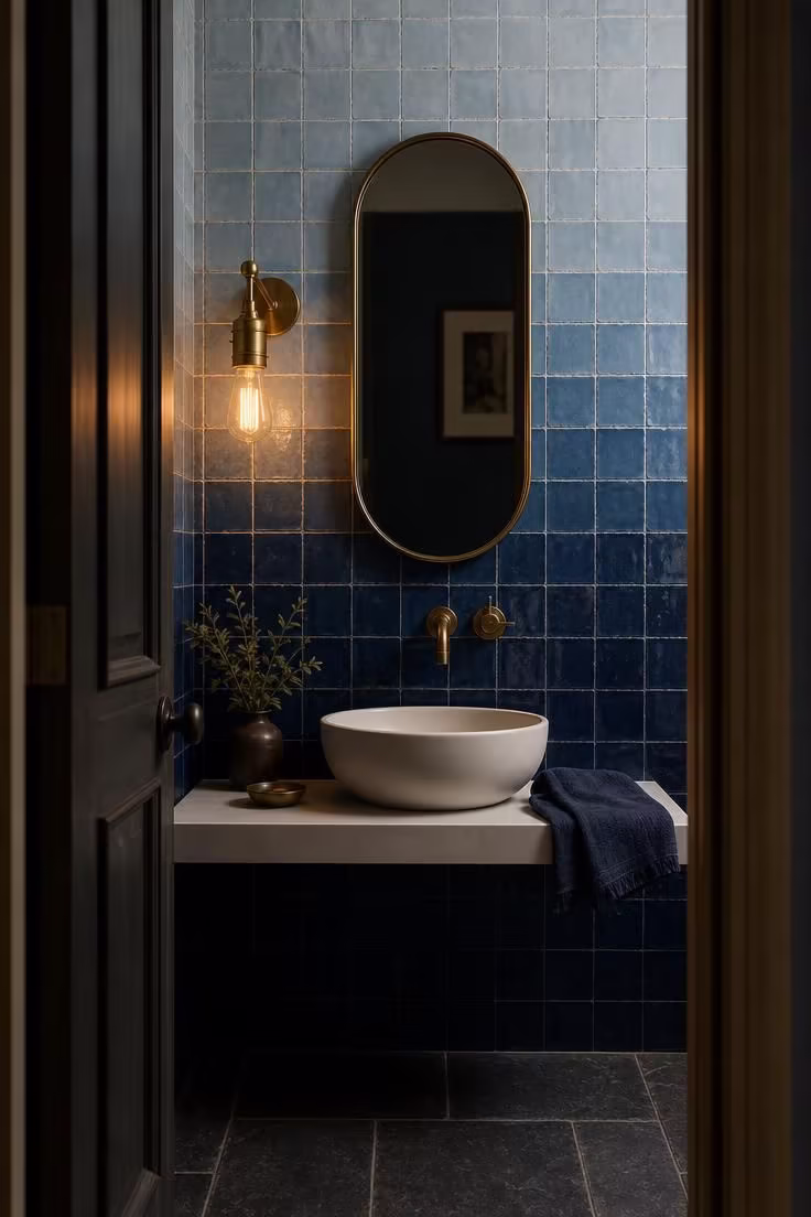 13 Modern Powder Room Ideas Packed With Personality 9 Ombre glazed tile wall graduating from navy to sky blue with a pill-shaped brass mirror in a modern powder room