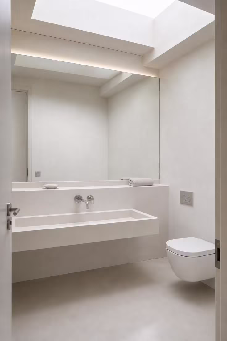 13 Modern Powder Room Ideas Packed With Personality 10 Modern powder room with a seamless poured resin floor and a wall-mounted matte white trough sink