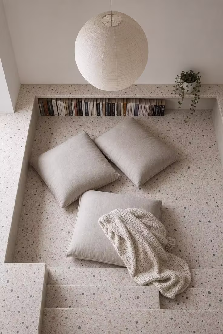 12 Modern Reading Nook Ideas for a Peaceful Retreat 5 Overhead view of a sunken terrazzo reading nook with oatmeal linen floor cushions and a rice paper pendant