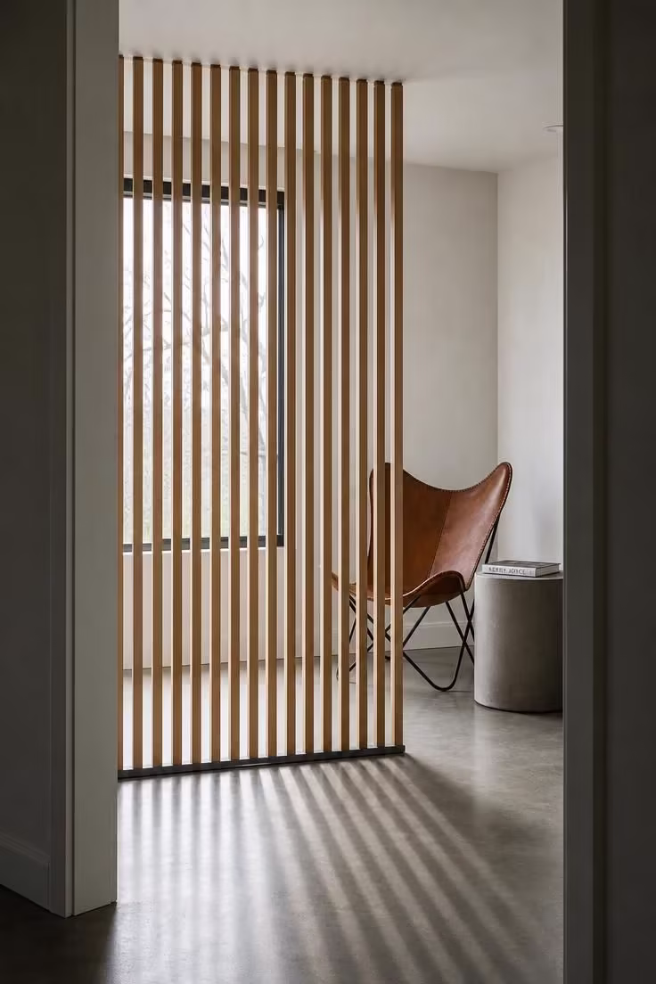 12 Modern Reading Nook Ideas for a Peaceful Retreat 10 White oak slatted screen filtering light onto a saddle leather butterfly chair in a modern reading corner