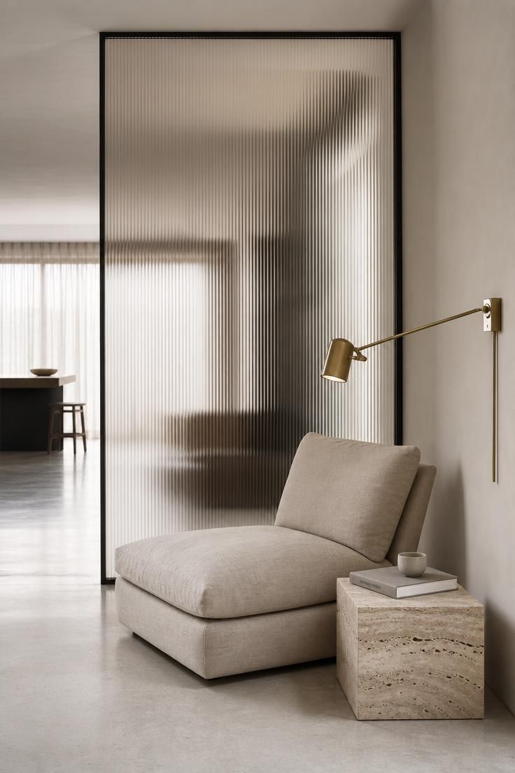12 Modern Reading Nook Ideas for a Peaceful Retreat 12 Ribbed glass partition with a stone-colored linen lounge chair and travertine side table in a modern reading nook