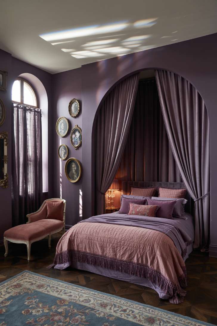 Moody plum bedroom with alcove canopy bed and antique chaise lounge
