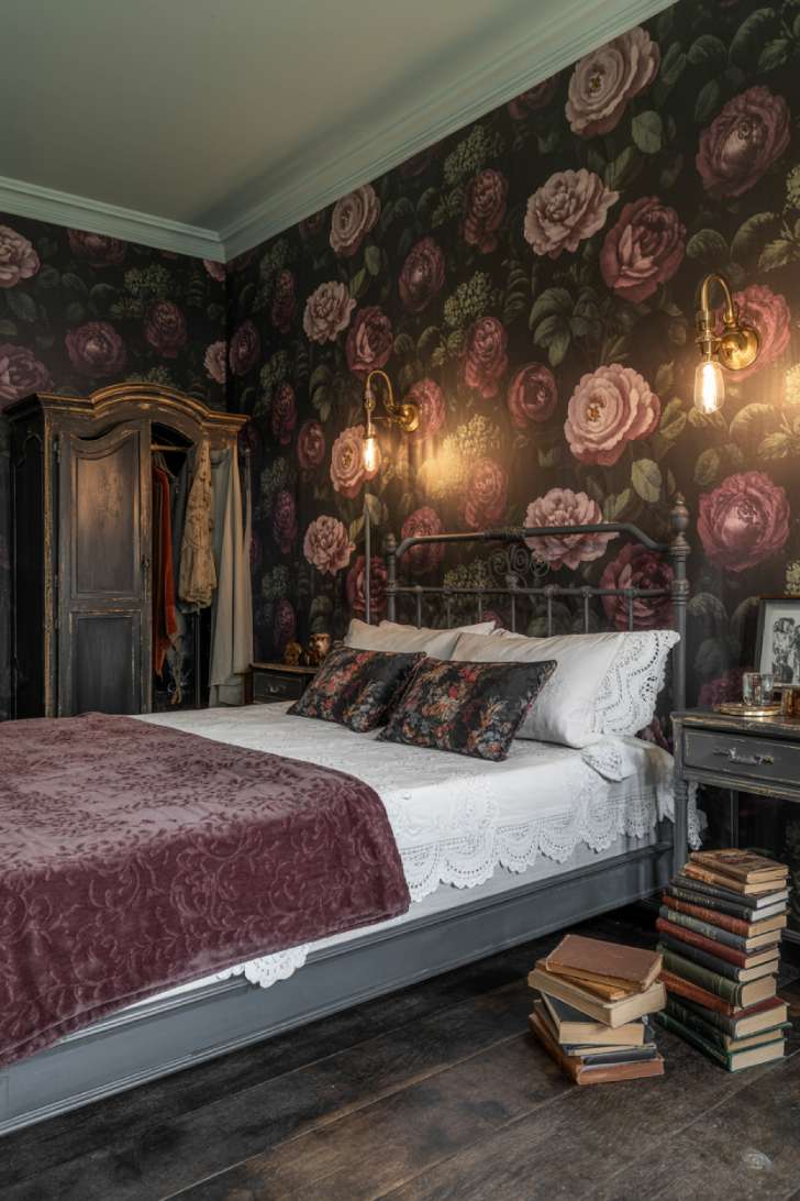 Dark floral wallpaper maximalist bedroom with antique iron bed and velvet coverlet