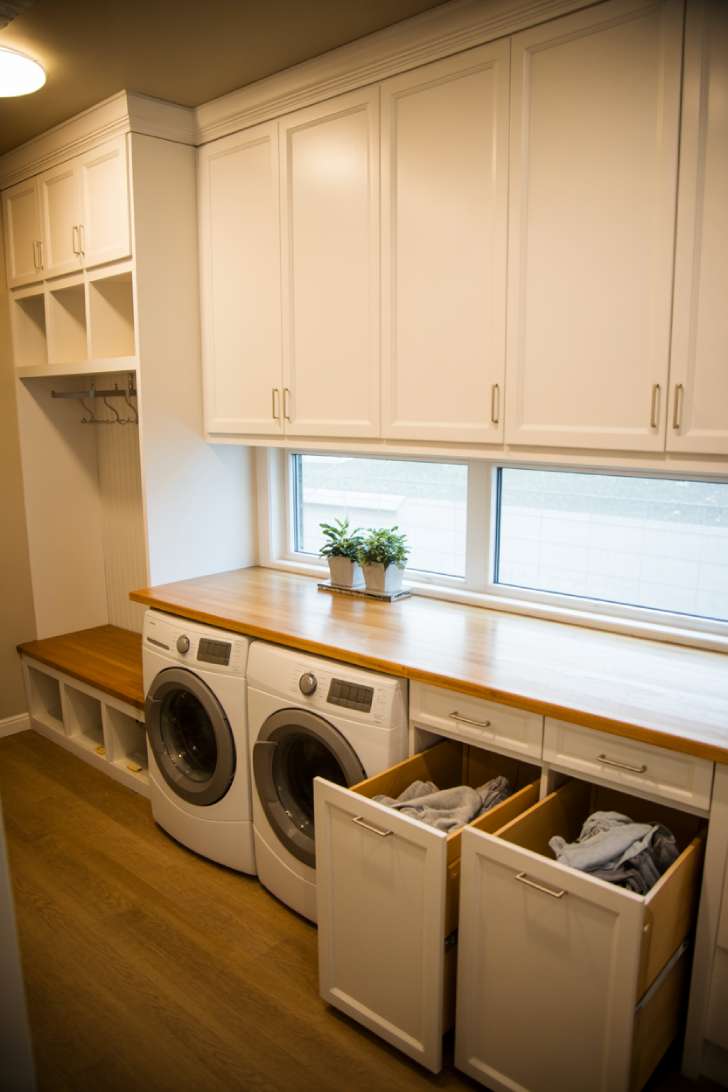 13 Bold Mudroom Laundry Room Ideas for a Stylish Space 6 Mudroom laundry room with butcher block folding station, integrated hamper drawers, and upper cabinetry