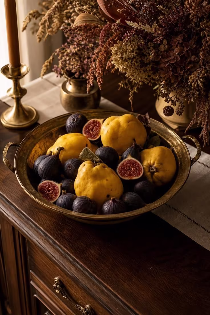 11 Cozy Natural Fall Decor Ideas for a Warm, Calm Home 10 Tarnished brass bowl of quince and figs on a walnut sideboard as natural fall decor.