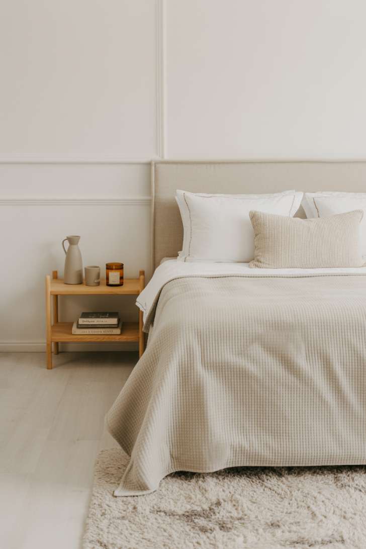 11 Charming Neutral Guest Bedroom Ideas for Warm Welcomes 5 A Scandinavian-style guest bedroom with a pale upholstered headboard, shag rug, wall-mounted oak shelves, and a bentwood chair in natural ash