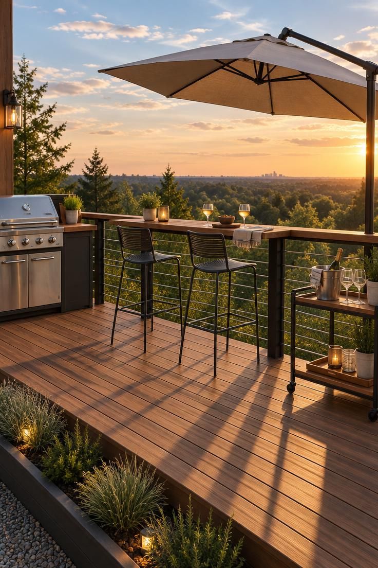 An elevated wooden deck with a counter attached to the railing, two metal stools facing outward, a small grill station to the left, and a tilted umbrella overhead.