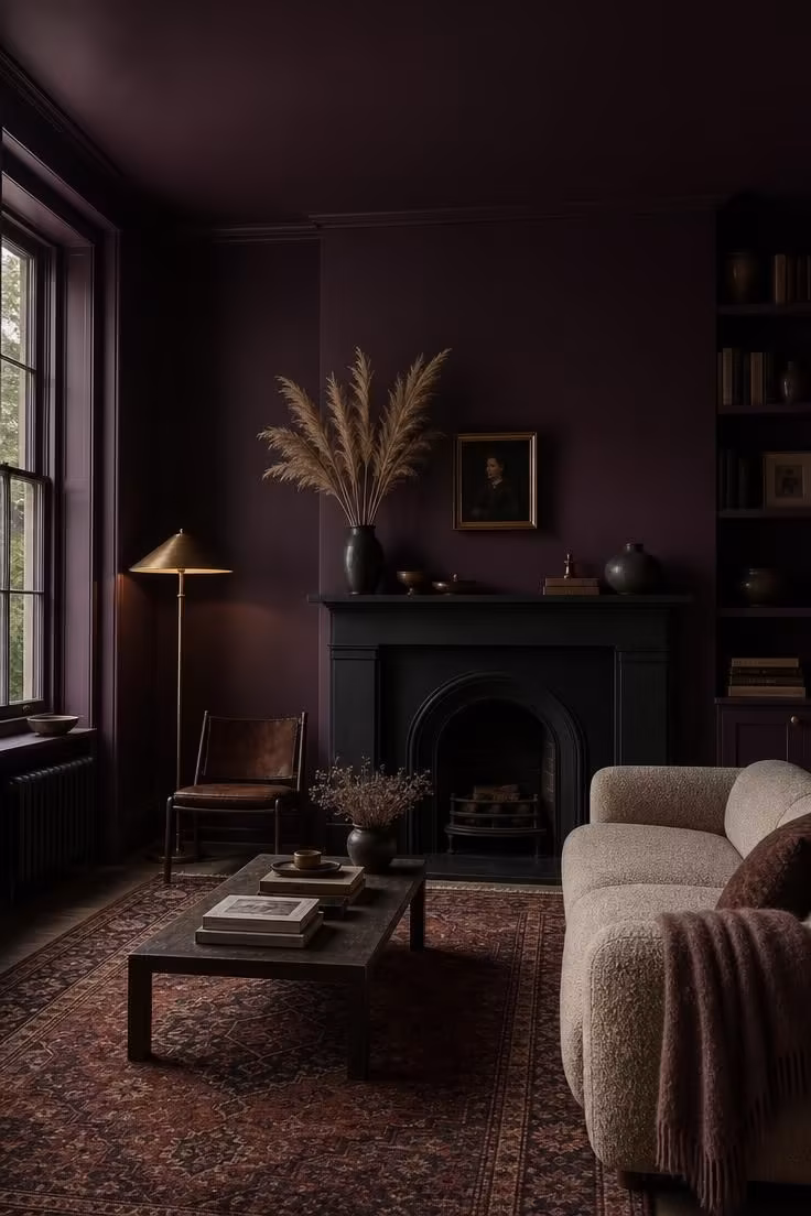 10 Painting Ideas for Living Room That Feel Instantly Rich 1 Living room with deep aubergine color drenched walls and a matte black fireplace surround.
