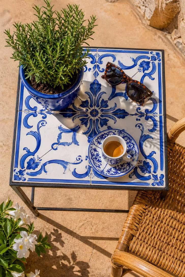 Mediterranean blue-and-white tile inlay side table with espresso cup and rosemary on a sunny patio