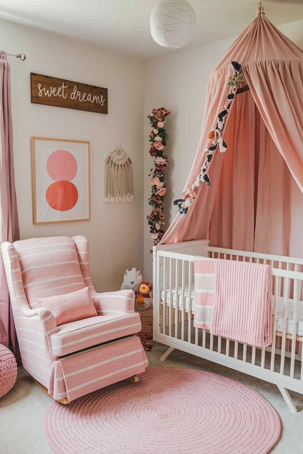 A highly detailed stylish pink boho nursery room decor. There is a crib with a pink and white striped blanket. There is a rocking chair with a pink and white striped pattern. The walls are adorned with a wooden sign that says "Sweet Dreams", a framed art piece with a white background and pink and orange circles, and a floral garland. There is a pink rug on the floor. There are pink curtains near the crib. The room has a warm and cozy ambiance.