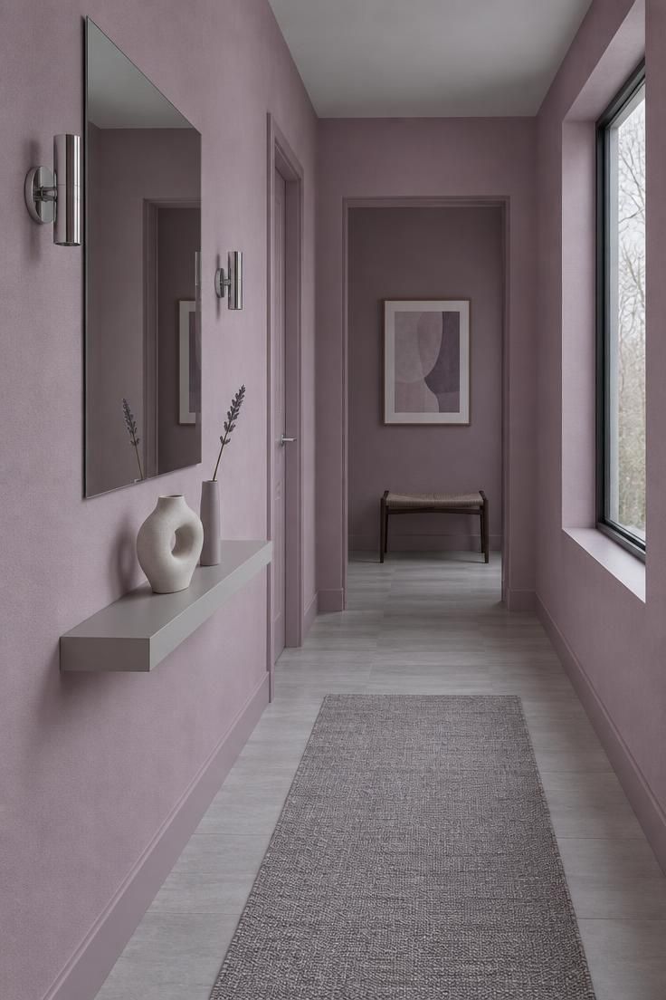 11 Warm Pink Hallway Ideas for a Welcoming First Impression 6 A hallway with mauve and lilac-leaning pink walls, chrome fittings, a frameless mirror, and a grey floor.