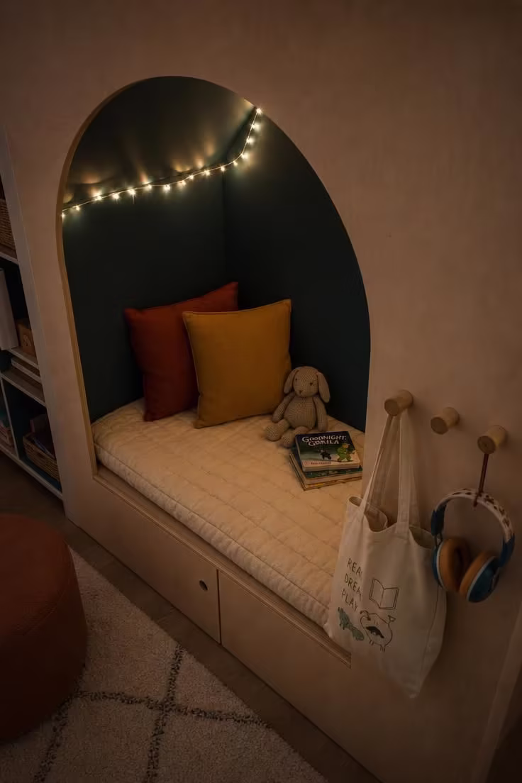 11 Inviting Playroom Reading Nook Ideas Kids Will Love 4 Arched plywood booth with teal painted interior and peg rail hooks in soft ambient low light